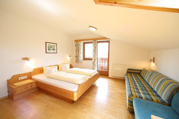 Bedroom with couch and balcony